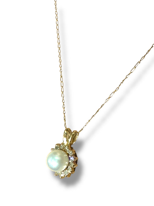 Gold necklace with pearl pendant on a white background
